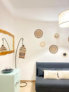 sala de estar con sofá azul y placas en la pared en Orchidea en Bari