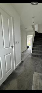 an empty room with a door and a staircase at The willows in Hardingstone