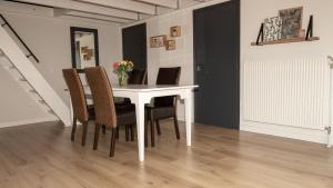 a dining room table with chairs and a vase of flowers at De Boalder in Hardenberg +5 photos