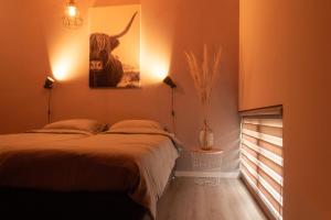 a bedroom with a bed and a picture of a bull at De Boalder in Hardenberg