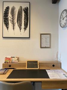 a desk with a picture of feathers on the wall at Bel appartement 2 pièces in Soufflenheim