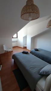 a bedroom with two beds and a chair at Morgon House in Molinaseca