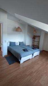 Un dormitorio con una cama grande con sábanas azules y una escalera en Morgon House, en Molinaseca