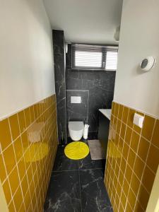 a bathroom with a toilet and a yellow circle on the floor at Casitas Wijchen - Nijmegen in Wijchen