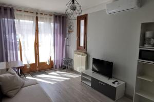 un salon avec une télévision et un canapé dans l'établissement Appartement proche plages et commerces, à La Ciotat