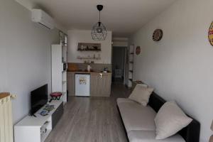 un salon avec un canapé et une cuisine dans l'établissement Appartement proche plages et commerces, à La Ciotat
