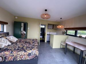 a bedroom with a bed and a table and a kitchen at Casitas Wijchen - Nijmegen in Wijchen