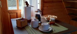 a table with a coffee maker and a basket of bread at La cabaña in San Antonio de Areco