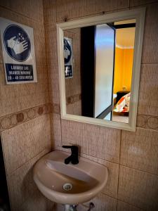 a white sink in a bathroom with a mirror at UMERSA SUITE HOTEL in Espinar