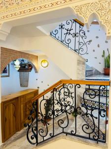 a staircase with wrought iron railings and a spiral staircase at Dar MD in Chefchaouene