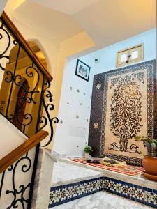 uma escadaria com piso em azulejo e uma parede em mosaico em Dar MD em Chefchaouene