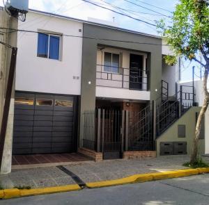 a large white house with a garage at Punto Golondrina in Alta Gracia
