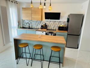 cocina con encimera con 2 taburetes y nevera en Appartement Premium 4 Stars - Antigone en Montpellier