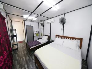 1 Schlafzimmer mit 2 Betten in einem Zimmer in der Unterkunft OYO 90960 Rajawali D'cabin Chalet Roomstay in Kuala Terengganu