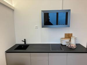 una cucina con lavandino e specchio sul muro di Lake Dream a Brissago