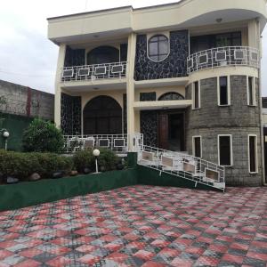 ein großes Haus mit einer roten Backsteineinfahrt in der Unterkunft Addis Joy Guesthouse in Addis Abeba