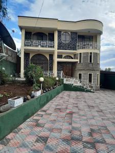 una casa grande con una entrada de ladrillo delante de ella en Addis Joy Guesthouse en Addis Abeba