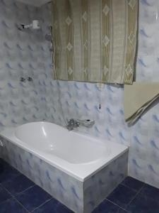 a white bath tub in a bathroom with a mirror at Addis Joy Guesthouse in Addis Ababa