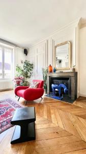 a living room with a red chair and a fireplace at Bright, spacious apartment in the heart of Lyon in Lyon