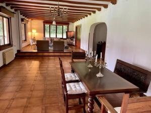 a dining room with a table and chairs and a living room at La Hondonada. in Somo