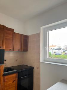 a kitchen with a window and a black stove at Falcon in Mali Lošinj