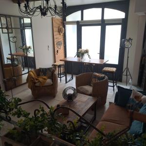 sala de estar con sofás, mesa y ventanas en Le Petit Patio, en Aigues-Mortes