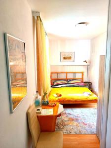 a bedroom with a yellow bed and a table at Gasthof Zemlinski Family Room in Payerbach