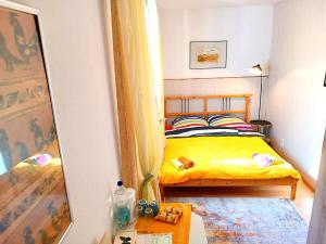 a small bedroom with a yellow bed and a mirror at Gasthof Zemlinski Family Room in Payerbach