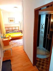 Habitación con ducha y dormitorio con cama. en Gasthof Zemlinski Family Room, en Payerbach