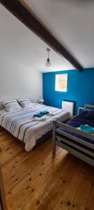a bedroom with a large bed and a blue wall at L'Ancre du Bessin - Proximité Bayeux et plages du débarquement - D-DAY - Spa en option - Accessible PMR in Saint-Vigor-le-Grand