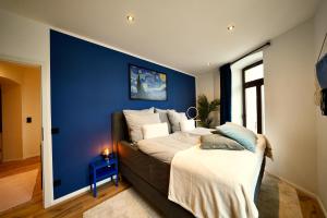 a bedroom with a blue wall and a bed at EDLER WOHNRAUM Einmalige 140 qm mit Kamin, Klimaanlage, Kaffeevollautomat, Netflix, 2 Balkonen & 2 Tiefgaragenplätzen in Chemnitz