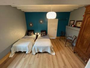 two beds in a room with blue walls and wooden floors at Maison de charme avec piscine in Vignoux-sous-les-Aix