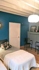 a bedroom with a bed and a blue wall at Maison de charme avec piscine in Vignoux-sous-les-Aix