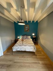 a bedroom with a bed and a blue wall at Maison de charme avec piscine in Vignoux-sous-les-Aix