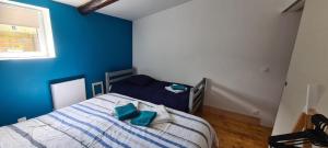 a bedroom with blue walls and a bed with blue pillows at L'Ancre du Bessin - Proximité Bayeux et plages du débarquement - D-DAY - Spa en option - Accessible PMR in Saint-Vigor-le-Grand