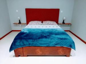 a bedroom with a large bed with a red headboard at Apartamento T1 in Praia