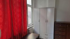 a bedroom with a red curtain and a window at Şirinevler Guest house in Istanbul