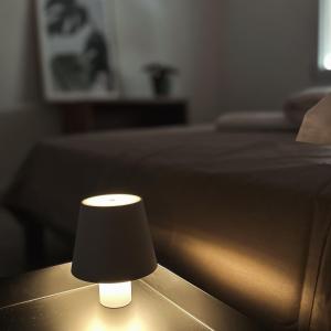 una lámpara negra sentada en una mesa junto a una cama en Martina’s Rooms, en Albignasego