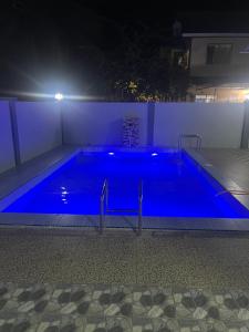 duży basen niebieski w nocy w obiekcie B&K Homestay Lahad Datu w mieście Lahad Datu