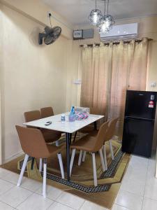 jadalnia z białym stołem i krzesłami w obiekcie B&K Homestay Lahad Datu w mieście Lahad Datu
