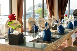 un lungo tavolo con sedie e bicchieri da vino di Hạ Long Aqua Legend Cruise a Ha Long