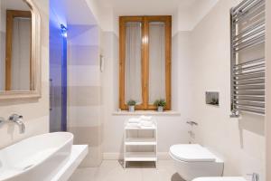 a white bathroom with a sink and a toilet at i Fiori de' Mario Suites in Rome