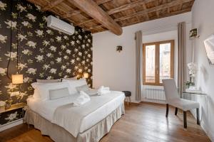 1 dormitorio con 1 cama con pared de flores en i Fiori de' Mario Suites, en Roma