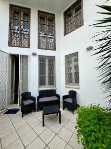 a patio with chairs and windows on a white building at Dimora Acanto in Bari
