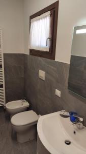 y baño con aseo, lavabo y espejo. en Agriturismo Il Moro, en Angolo Terme