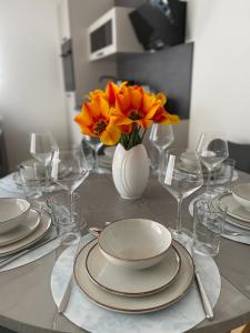 une table avec des assiettes et un vase de fleurs dans l'établissement Casa Estella, à Rust