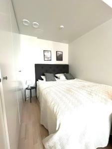 Un dormitorio con una cama blanca grande y una ventana en Airport brand new 1BR apartment fully equipped, en Vantaa