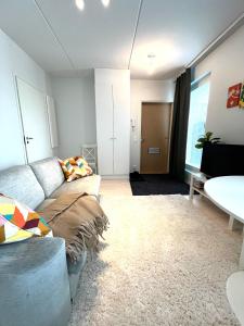 un soggiorno con divano e tavolo di Airport brand new 1BR apartment fully equipped a Vantaa