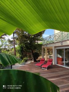 a group of red chairs sitting on a deck at Suite et Spa Les Abatilles in Arcachon