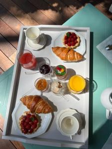 a tray with pastries and croissants on a table at Suite et Spa Les Abatilles in Arcachon